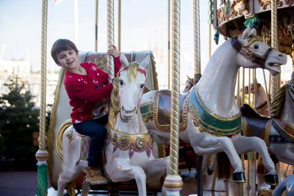 メリーゴーランド カルーセルの地ヨーロッパ アクティブな子供 冬に甘い男の子 サンタ クロースに乗ってそり — ストック写真