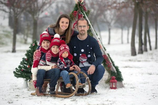 雪の中で楽しい屋外クリスマスを過ごし ティーピー クリスマスの装飾で遊んでいる子供たちと幸せな家族 — ストック写真