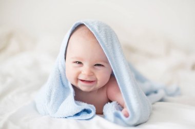Şirin bebek çocuk, rahatlatıcı banyo sonra yatakta mutlu bir şekilde gülümseyerek, gündüz