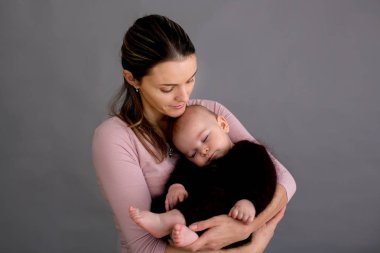 Onun yeni doğan bebek çocuk okşama, onun kollarında etrafında ve mutluluktan gülümseyen genç anne,
