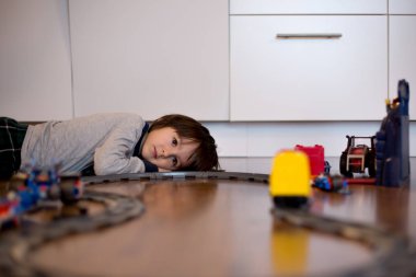 Bir oyuncak tren ile katta oturma odasında oynayan çocuk çocuk