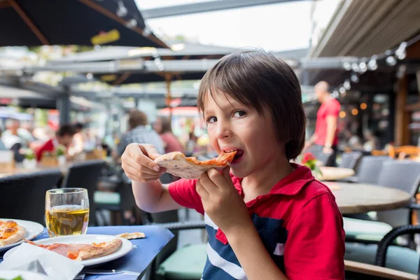 可爱的孩子 在餐馆吃比萨饼 愉快地微笑和咬 — 图库照片