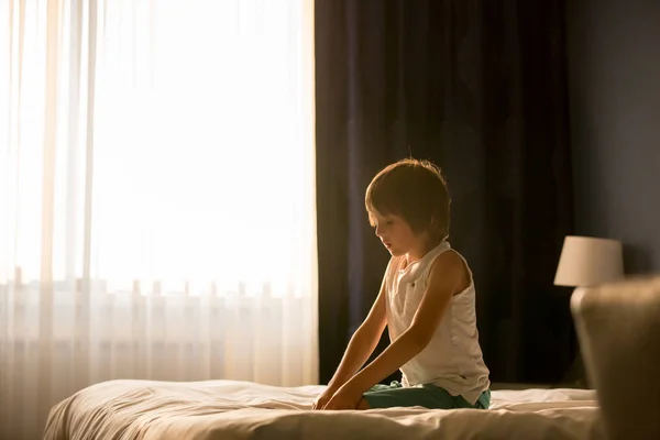 人の兄弟の子供 男の子と一緒に 遊んで 日当たりの良い寝室のベッドの上に座って 彼の兄がバックライトします — ストック写真