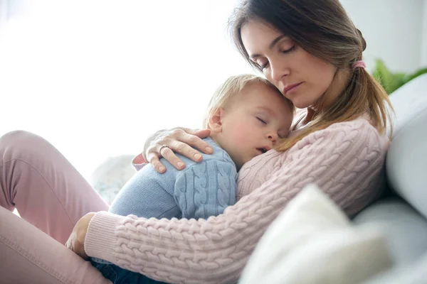 Madre Joven Sosteniendo Niño Enfermo Abrazándolo Casa Sala Estar Soleada —  Fotos de Stock