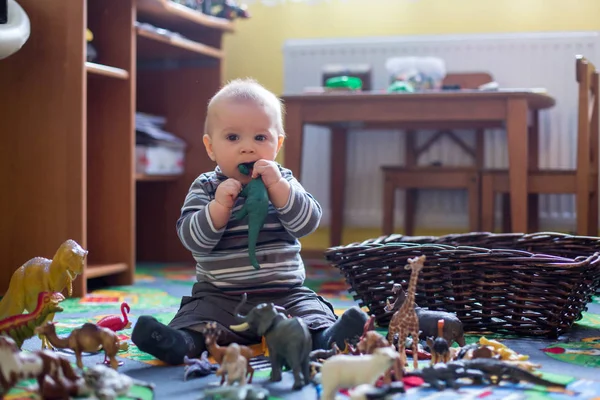 美しい小さな男の子 カメラ 恐竜彼屋内子供のプレイルームで撮影の周りに笑顔の幼児 — ストック写真