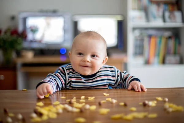 かわいい小さな幼児男の子コーンフレークを食べると台所で笑顔 — ストック写真