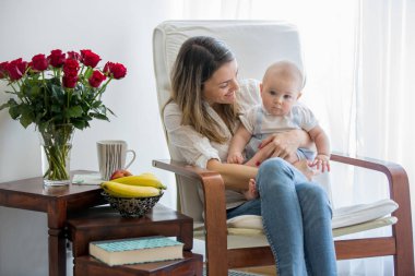 Anne, onun yürümeye başlayan çocuk ve büyük kardeşi, okuma kitabı, gülümseyen, emzirme ile oynama