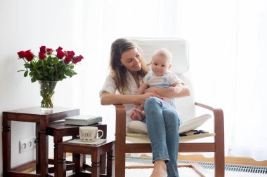 Anne, ona kitap okumak onun bebek çocuk sallanan sandalyede ile oynarken
