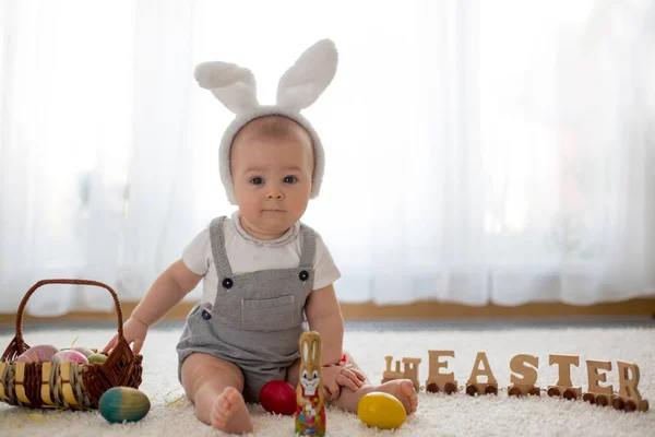 可爱的小蹒跚学步的孩子 小男孩 在阳光明媚的客厅玩复活节巧克力兔子和五颜六色的复活节彩蛋 — 图库照片