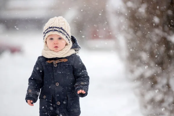 宝宝在雪地里玩泰迪熊 小男孩身穿蓝色外套 提着手提箱和泰迪熊 在冬季公园的室外玩耍 孩子们在雪地公园玩耍 — 图库照片