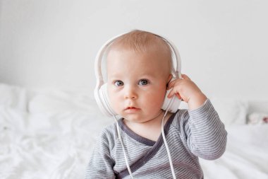 Sevimli küçük toddler bebek çocuk müzik dinleme yatakta baş telefonları ile
