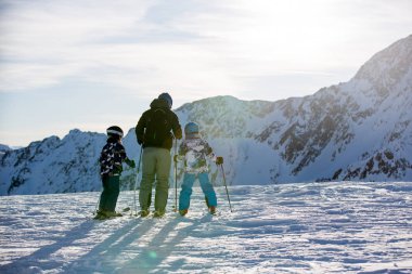 Mutlu insanlar, çocuklar ve yetişkinler, güneşli bir günde Tyrol dağlarda Kayak. Çocuklar eğleniyor kayak yaparken