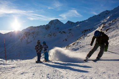 Mutlu insanlar, çocuklar ve yetişkinler, güneşli bir günde Tyrol dağlarda Kayak. Çocuklar eğleniyor kayak yaparken