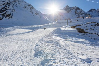 Mutlu insanlar, çocuklar ve yetişkinler, güneşli bir günde Tyrol dağlarda kayar. Çocuklar eğleniyor sledging süre