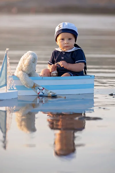 ボート テディー ベアおよび海 美しい夕日 反射の端に日没で魚と遊ぶかわいい赤ちゃん子供甘い少年 — ストック写真