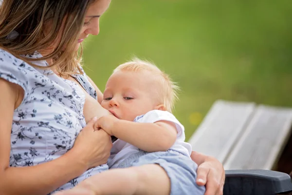 若い母親 彼彼女の裏庭で午後に彼女の男の子の赤ちゃん 母乳を保持は Paece リラックスします — ストック写真