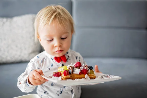可爱的幼儿生日男孩 在家里吃与覆盆子 椰子和巧克力的比利时华夫饼 — 图库照片