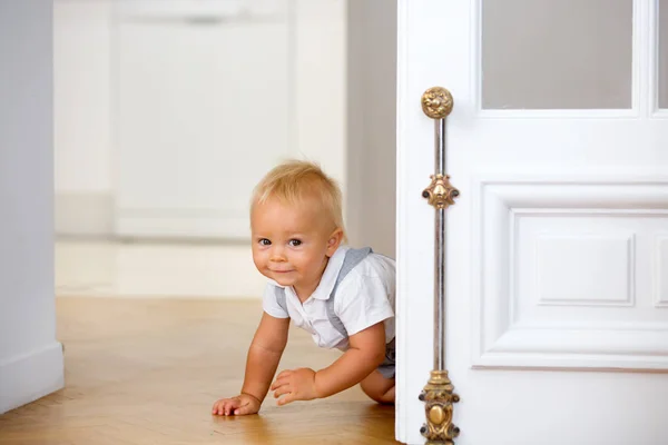 Kleine schattige baby kind, jongen, kruipen van achter een deur — Stockfoto