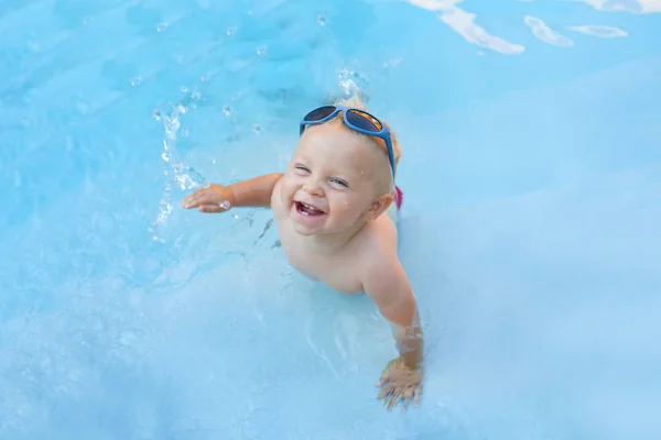 Niño lindo, jugando con el barco inflable en la piscina — Foto de Stock