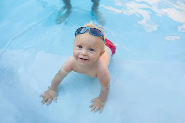 Niño lindo, jugando con el barco inflable en la piscina —  Fotos de Stock