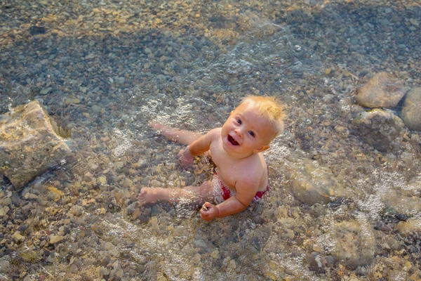 Niño lindo, niño pequeño, disfrutando de la puesta de sol sobre un lago — Foto de Stock