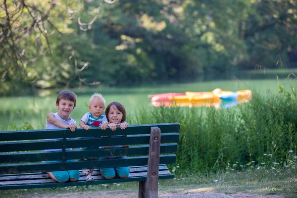 Tre barn, syskon, gå tillsammans hand i hand i p — Stockfoto