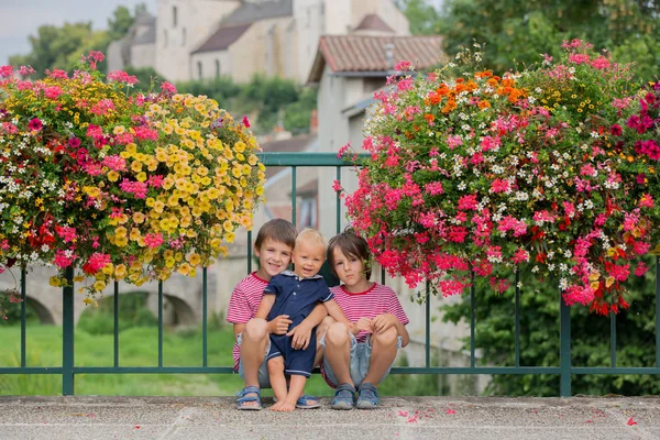 Bambini in piedi di fronte a vasi di fiori nella città di Chatill — Foto Stock