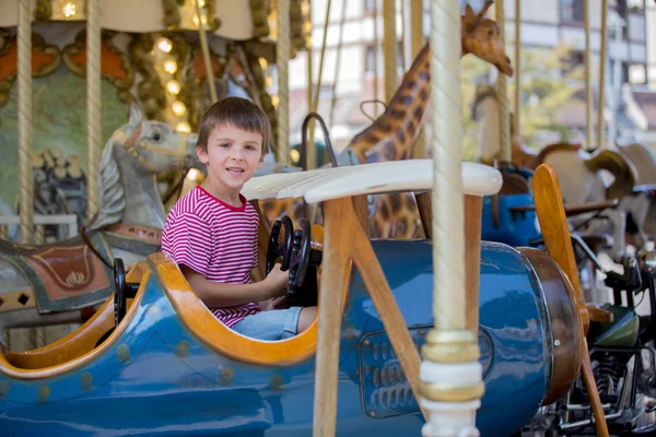 Children going on Merry Go Round, kids play on carousel — Stock Photo, Image