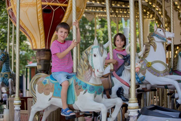 Children going on Merry Go Round, kids play on carousel — Stock Photo, Image