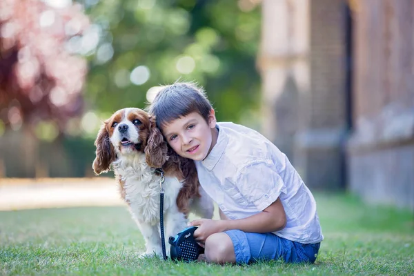 Hermosos niños preescolares, jugando con un perro dulce a la par — Foto de Stock