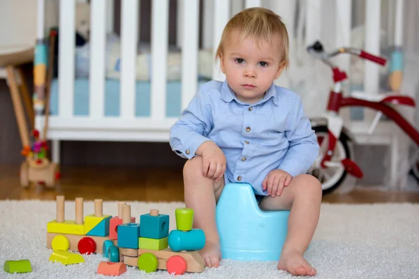 Cute toddler boy, potty training, playing with his teddy bear