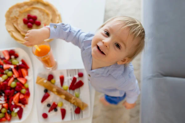 Bambino bambino, ragazzo, mangiare frittelle con un sacco di frutta e succhi — Foto Stock