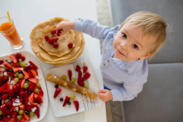 幼児、男の子、果物や juic のたくさんのパンケーキを食べる — ストック写真
