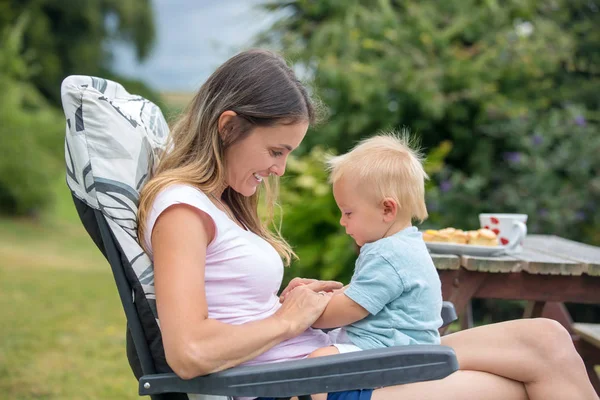 Jovem mãe, segurando seu menino bonito ao ar livre, abraçá-lo, kis — Fotografia de Stock