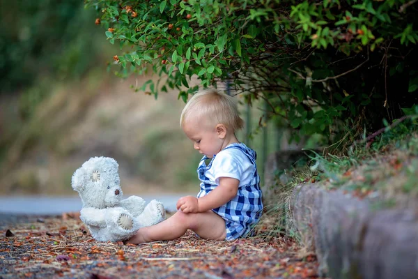 Adorable niño, jugando con el oso de peluche en el parque — Foto de Stock