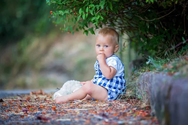 Adorable niño, jugando con el oso de peluche en el parque — Foto de Stock