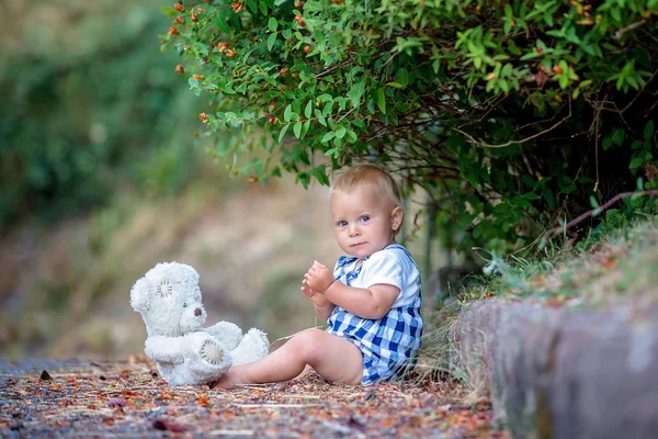 Criança adorável, brincando com ursinho de pelúcia no parque — Fotografia de Stock