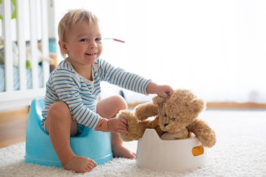 Sevimli Toddler çocuk, lazımlık eğitim, onun oyuncak ayı ile oynuyor 