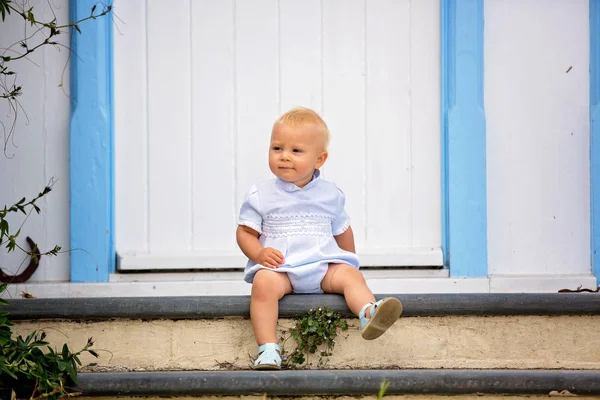 Bellissimo bambino, seduto sul portico davanti per le strade di — Foto Stock