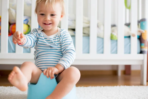 Cute toddler boy, potty training, playing with his teddy bear