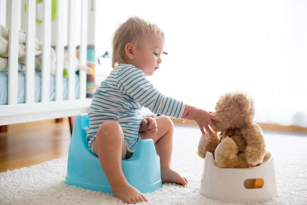 Menino bonito da criança, treinamento potty, brincando com seu ursinho de pelúcia — Fotografia de Stock
