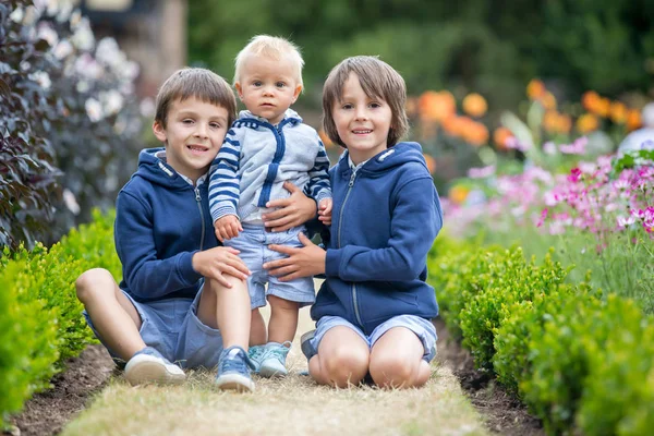Gyönyörű gyerek csodálatos virágoskertben — Stock Fotó