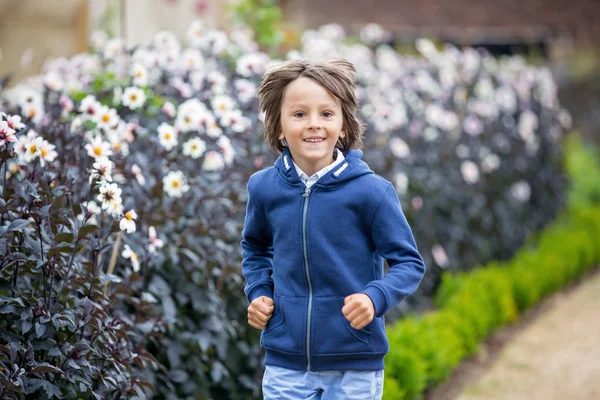 Copil frumos în grădină de flori uimitoare — Fotografie, imagine de stoc