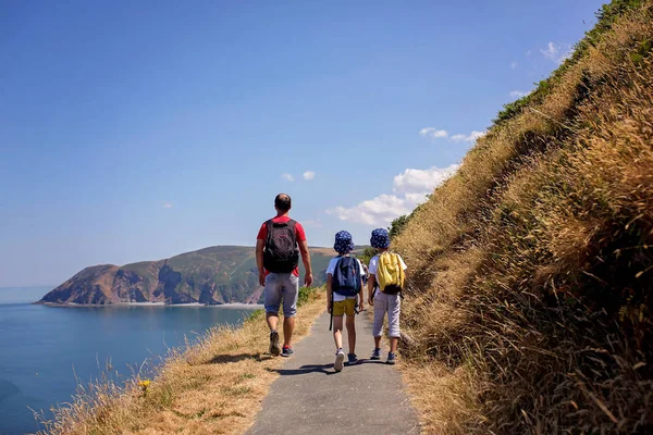Father and two boys, family walking on a small path along the st — Stock Photo, Image