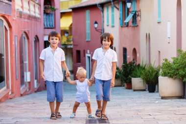 Küçük bebek çocuk ve onun büyük kardeşler, renkli stre üzerinde yürüyüş
