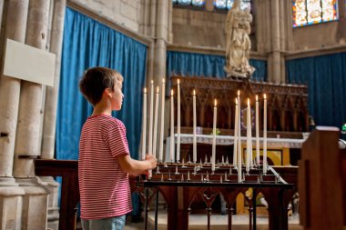 Küçük çocuk dua ve Ortodoks churc bir mum koyar