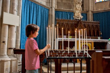 Küçük çocuk dua ve Ortodoks churc bir mum koyar