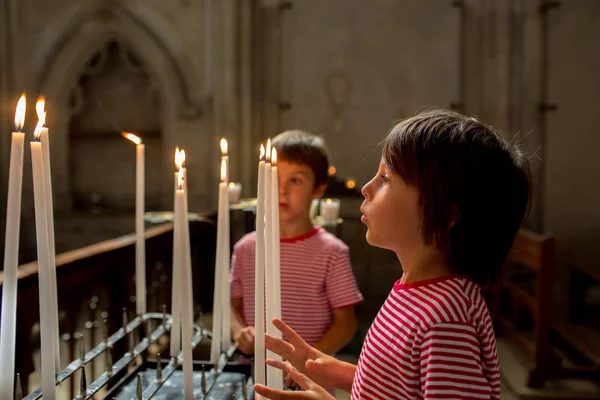 Küçük çocuk dua ve Ortodoks churc bir mum koyar