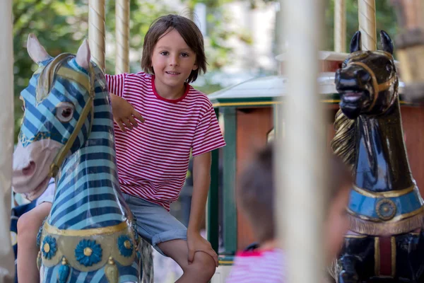 Barn som åker på Merry Go Round, barnen leker på karusellen — Stockfoto