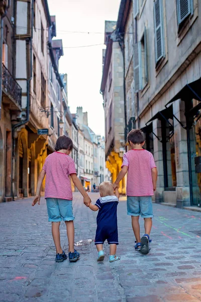 Three children, siblings, boys, walking hand in hands on the str — Stock Photo, Image